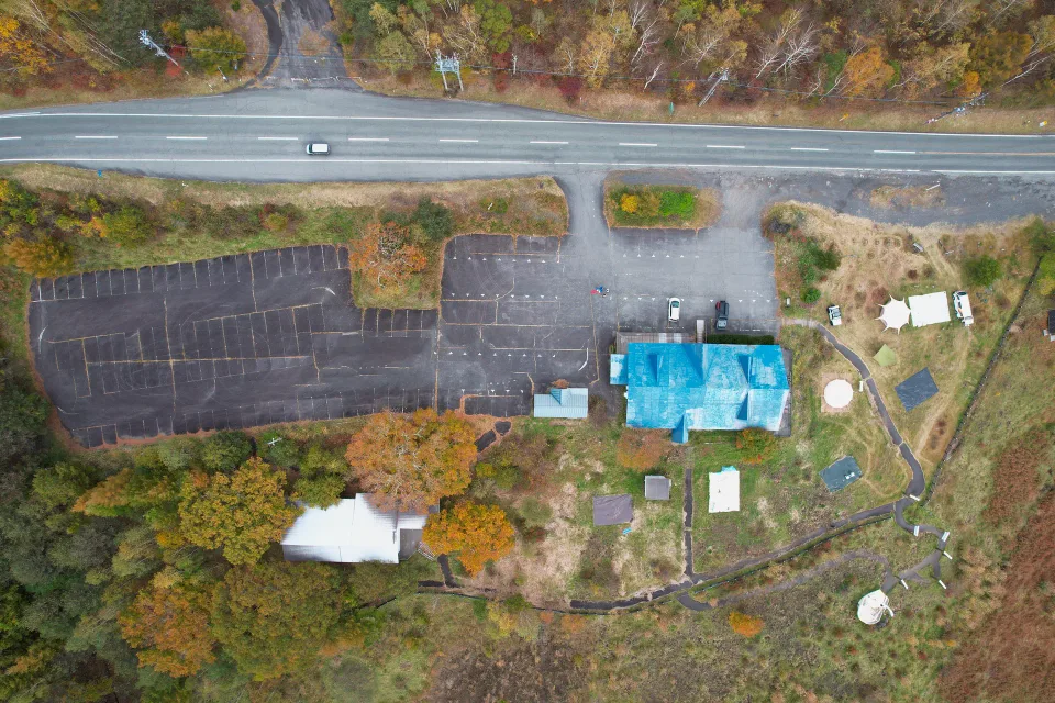 真上から見た敷地全体。道路、大駐車場、ホール、草地をめぐる小道
