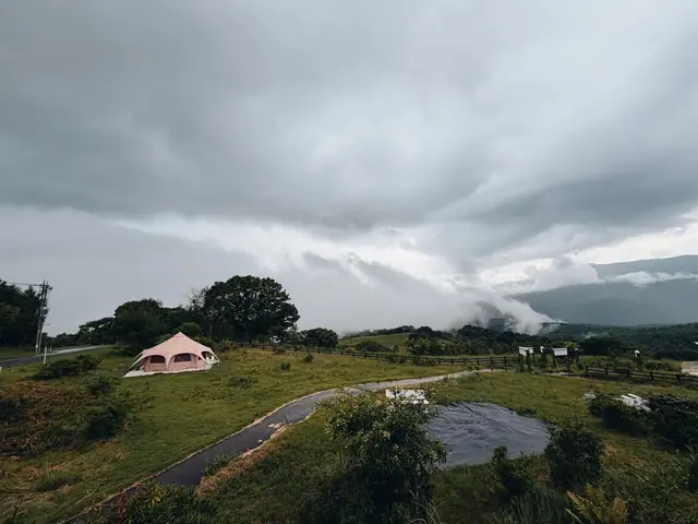 The highland view from the workplace — a bell tent and cloud-wrapped mountains