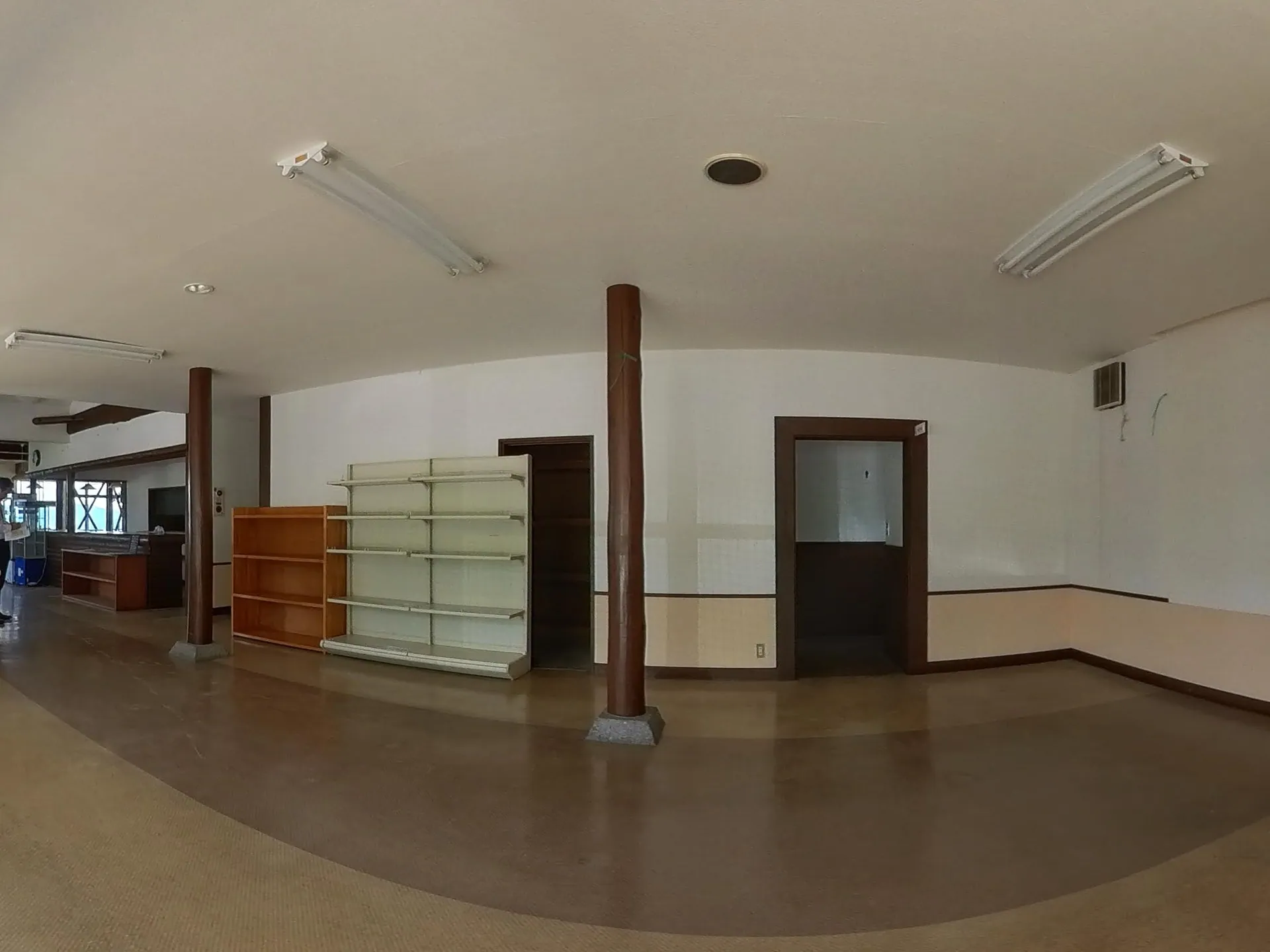 360° — August 2025, the old shop room as we found it: empty shelving units, a bare counter, fluorescent tubes overhead