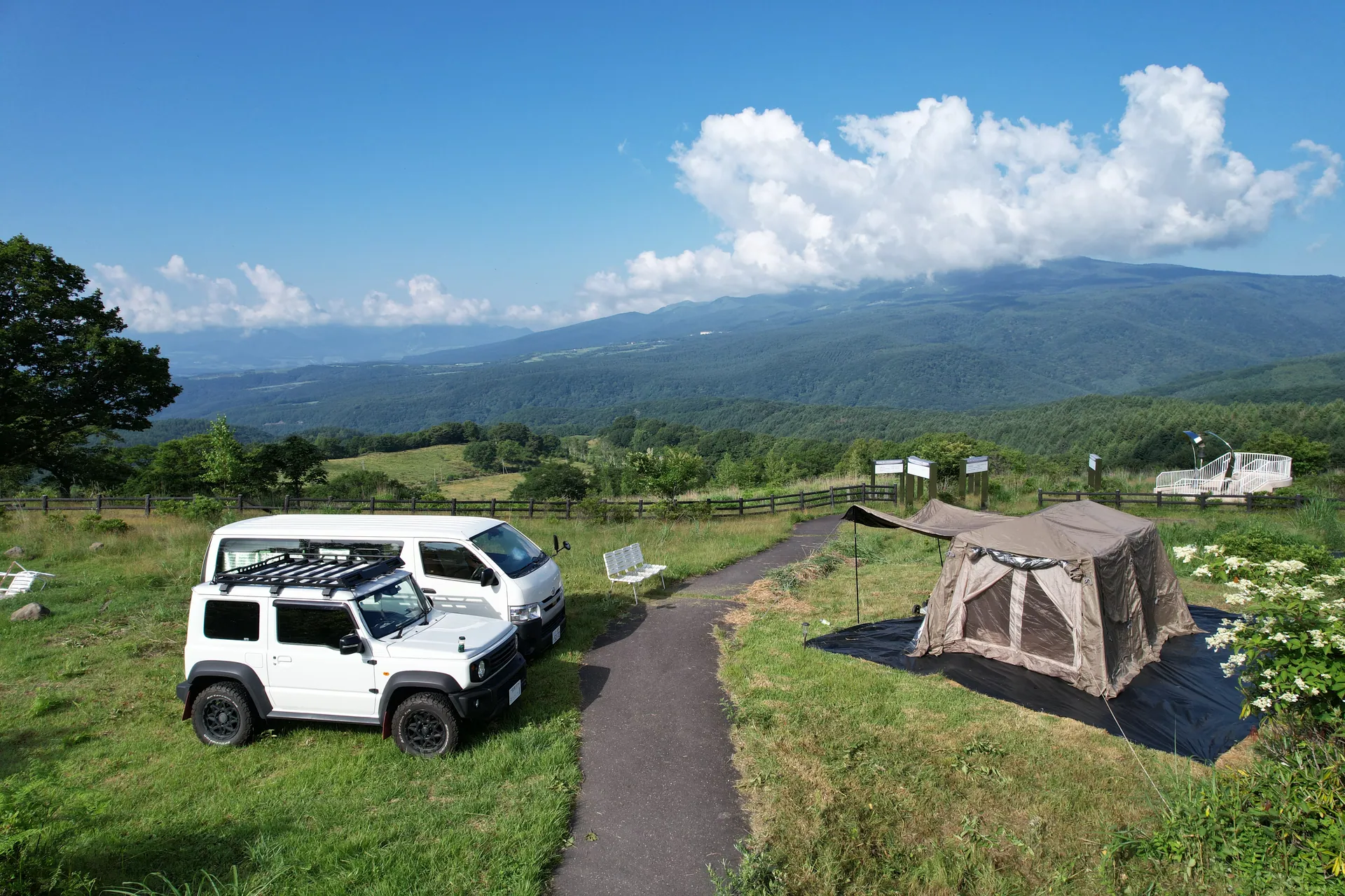 高原を望む夏の車中泊サイト — テントとジムニー、バン
