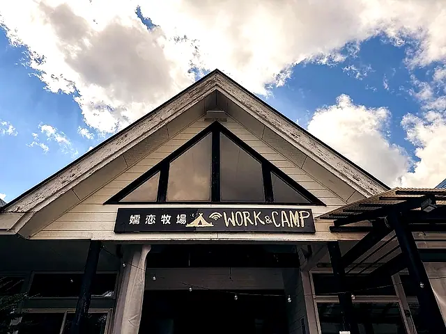 ホール破風の下、手描きの「嬬恋牧場 WORK & CAMP」看板